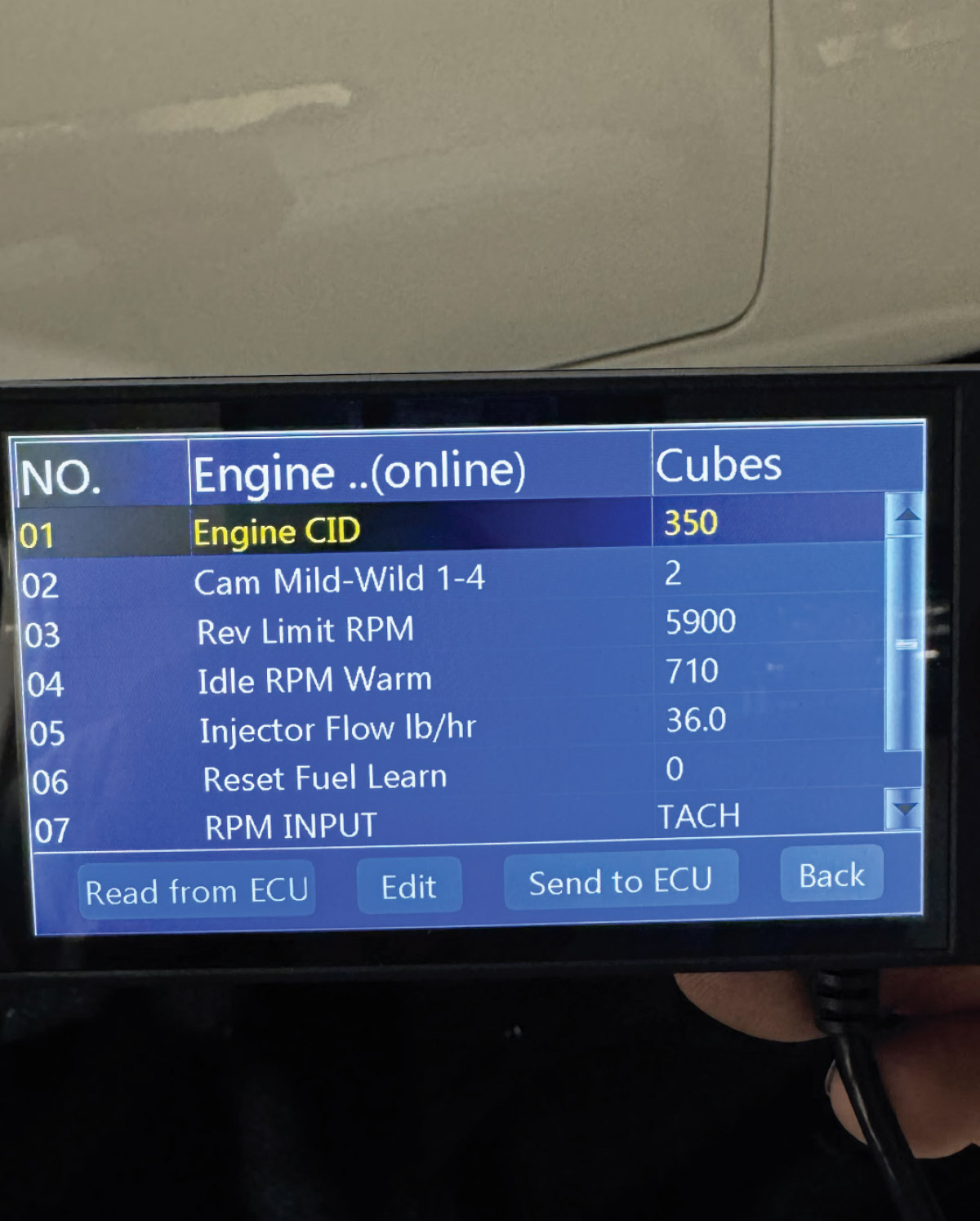 FiTech handheld controller displaying setup parameters for engine tuning, including RPM and fuel injector settings