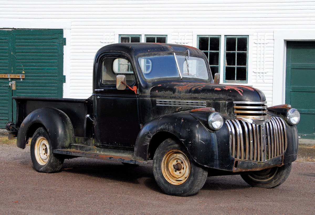 1946 Chevy Truck, black patina, pre-restoration parked by a garage