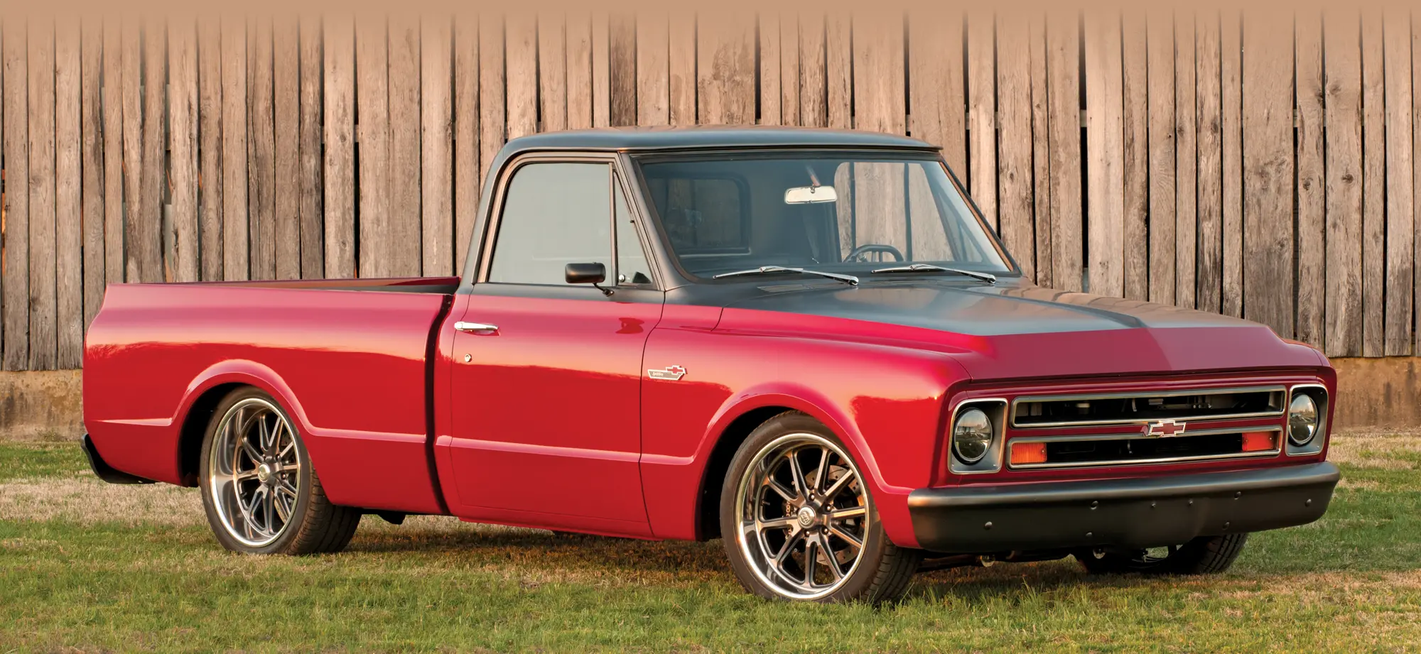 1967 Chevy C10 in red and matte gray with custom wheels and lowered suspension for a modernized classic look