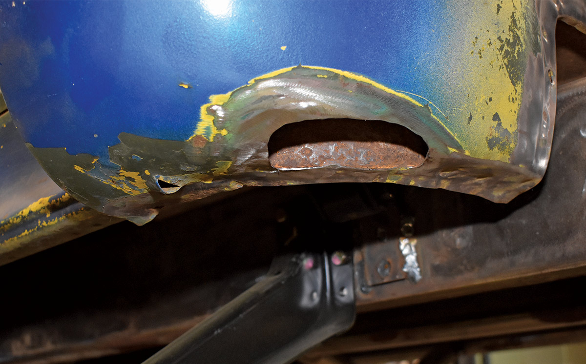 Severely rusted and damaged lower cab corner before repair