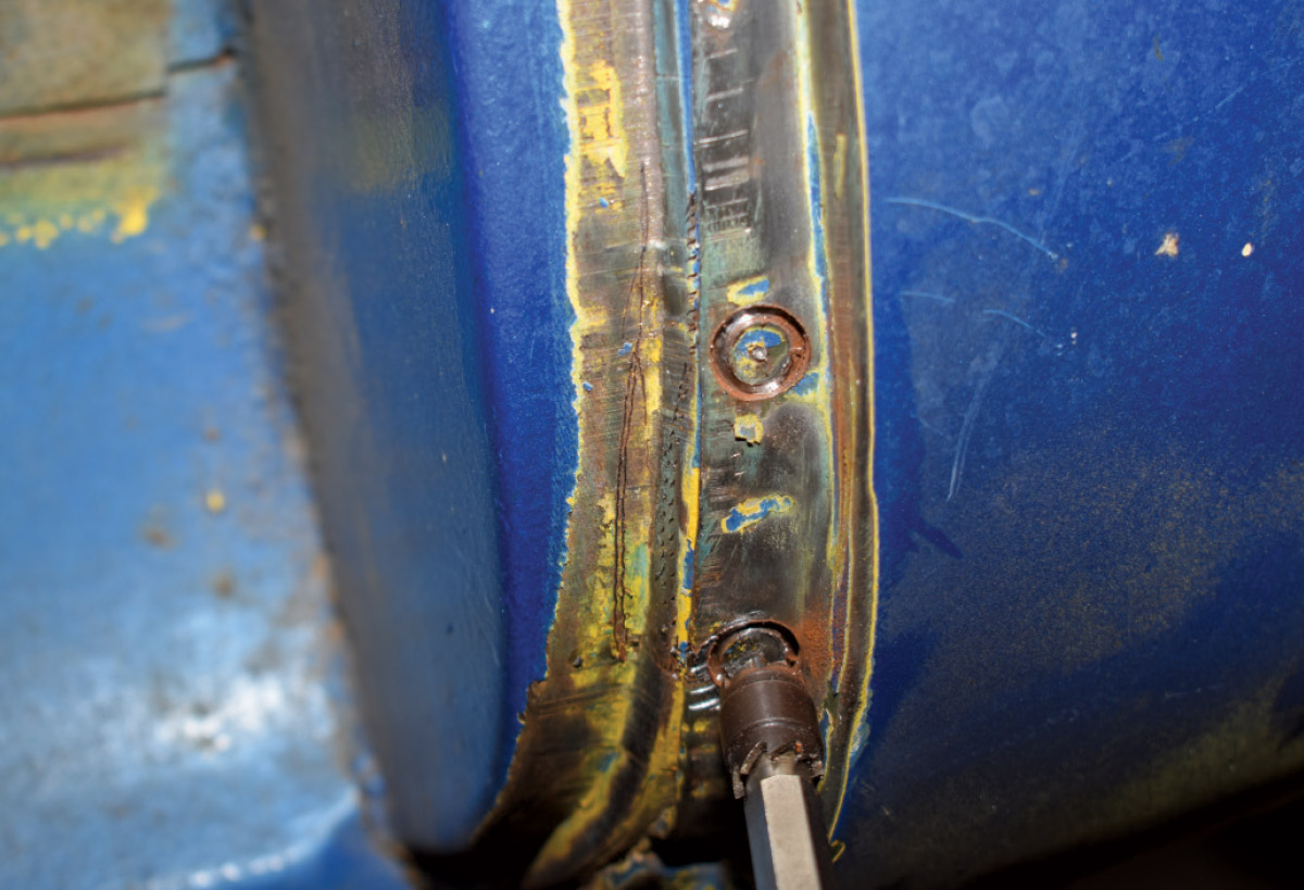 Close-up of spot weld removal in progress on the cab corner