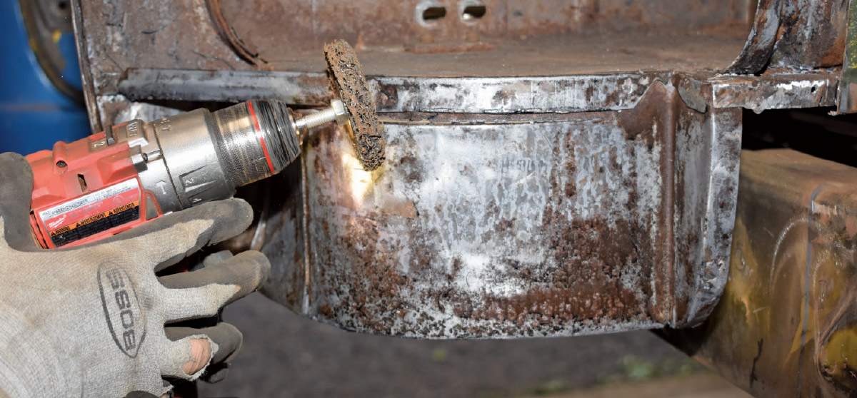 Cleaning and preparing the inner cab structure with a drill and abrasive disc