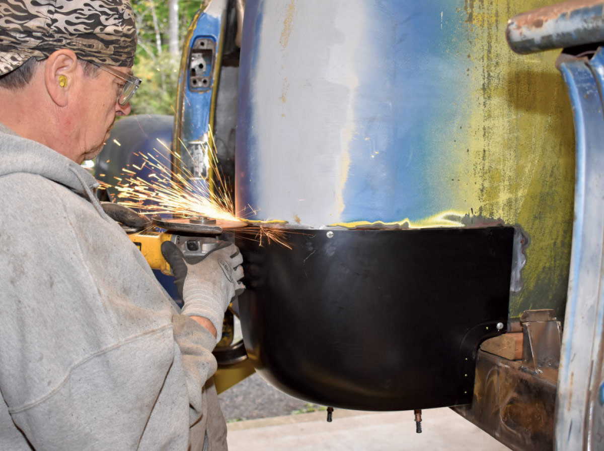 Grinding down welds to create a seamless finish on the new panel