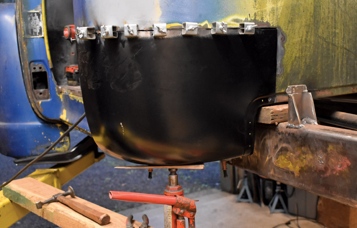 Replacement cab corner clamped in place, supported by a hydraulic jack
