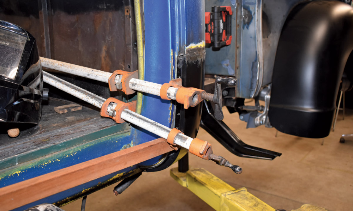 Large clamps securing a rocker panel replacement for precise welding alignment