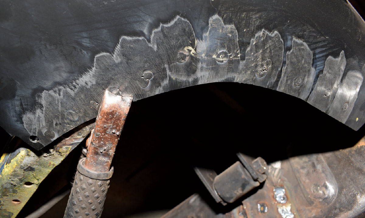 Close-up of ground-down spot welds on a fender patch panel