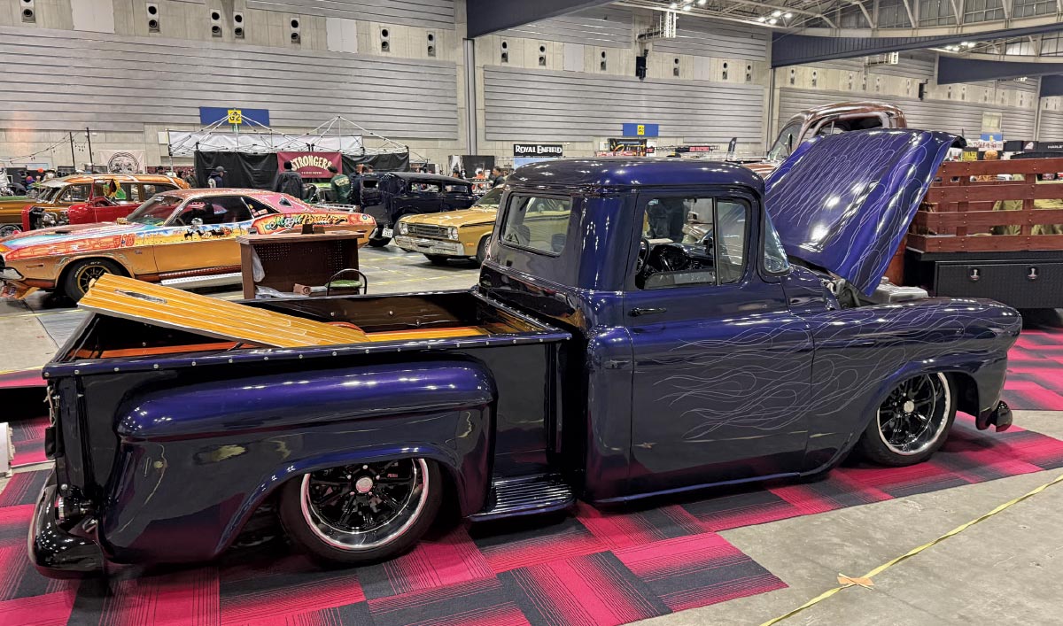 1955 Chevrolet 3100 – Deep blue with ghost flames and a wood bed, sitting low