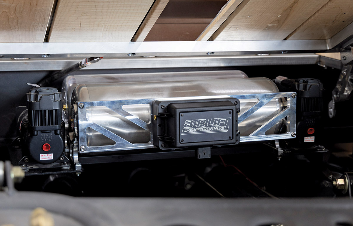 Fully installed Air Lift Performance system under a slatted wood truck bed