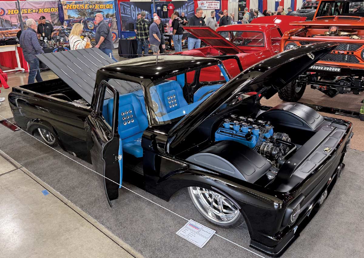 3/4 side view of low black truck with all doors open showing off its blue interior