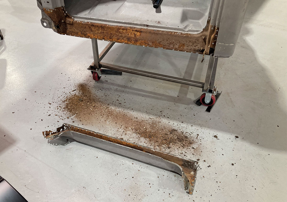Extensive rust damage along the lower cab structure before repair