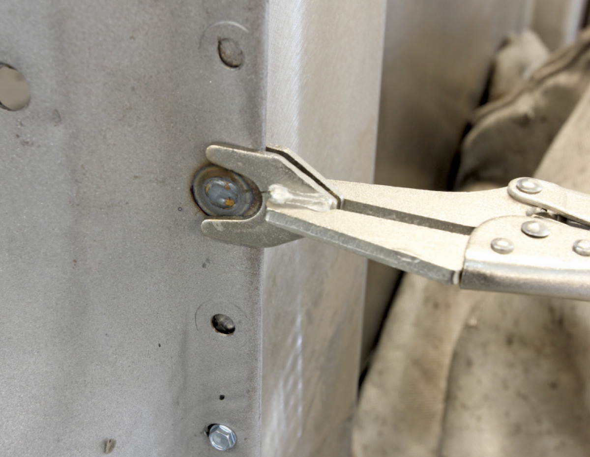 Locking pliers securing a plug weld in the cab structure