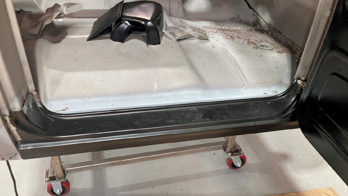 Freshly installed rocker panel and inner floor structure secured in place