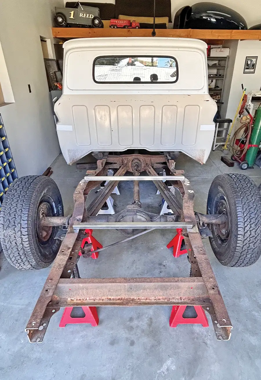 frame stripped down and supported on jack stands for restoration