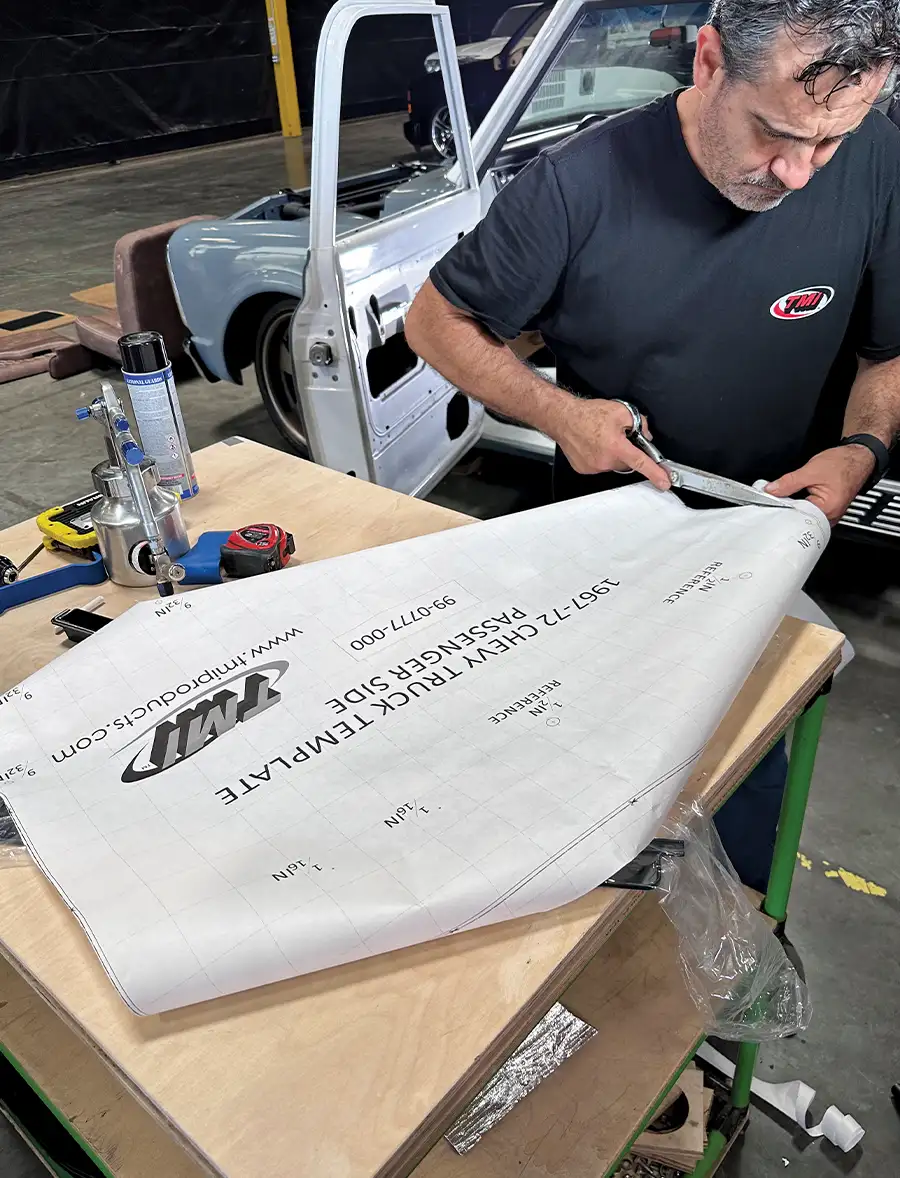 Technician cutting TMI door panel template for precise fitment