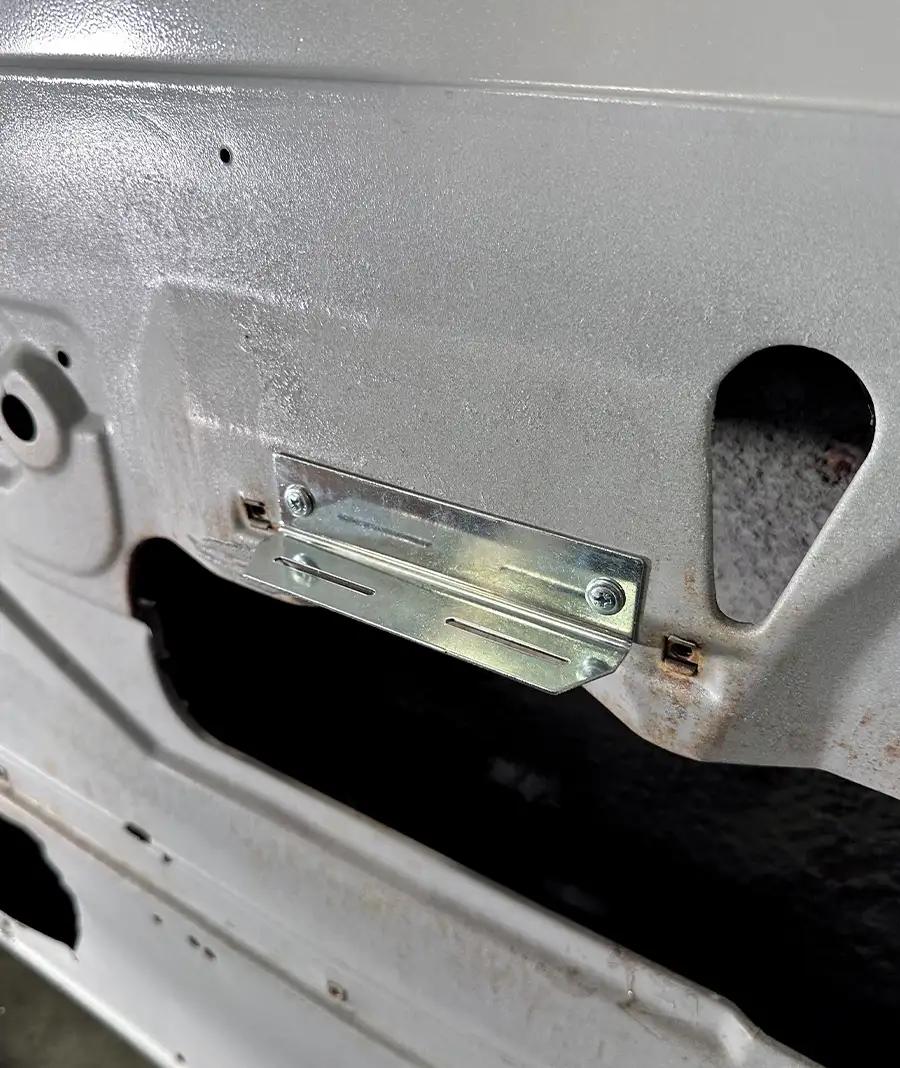 Metal bracket securely mounted inside door for panel attachment