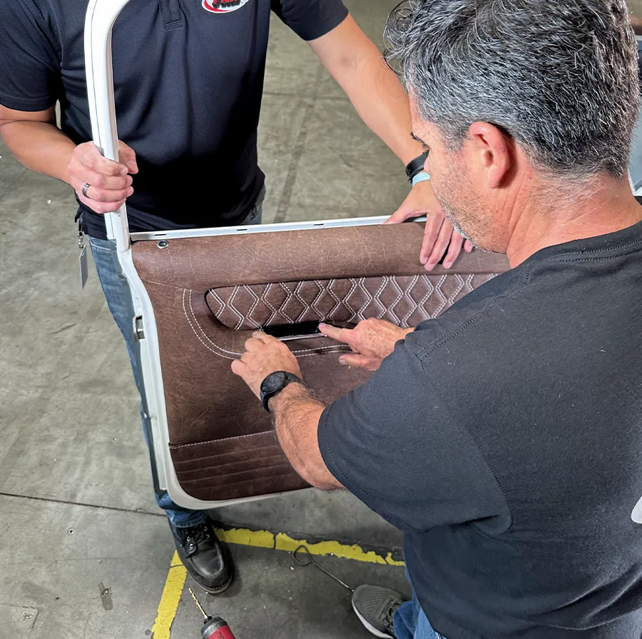 Brown leather door panel being installed with diamond-stitched armrest
