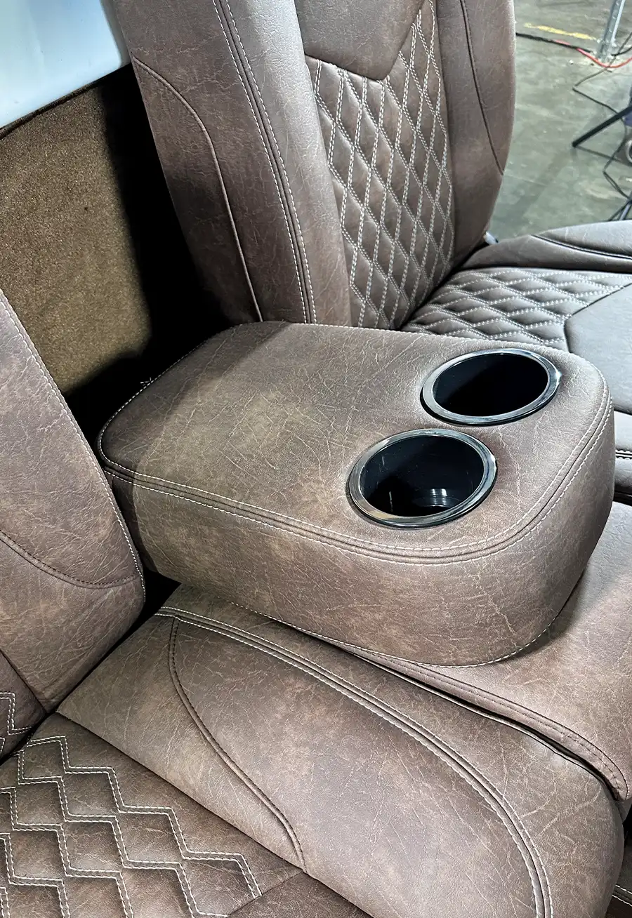 Close-up of brown leather seat with integrated cup holders