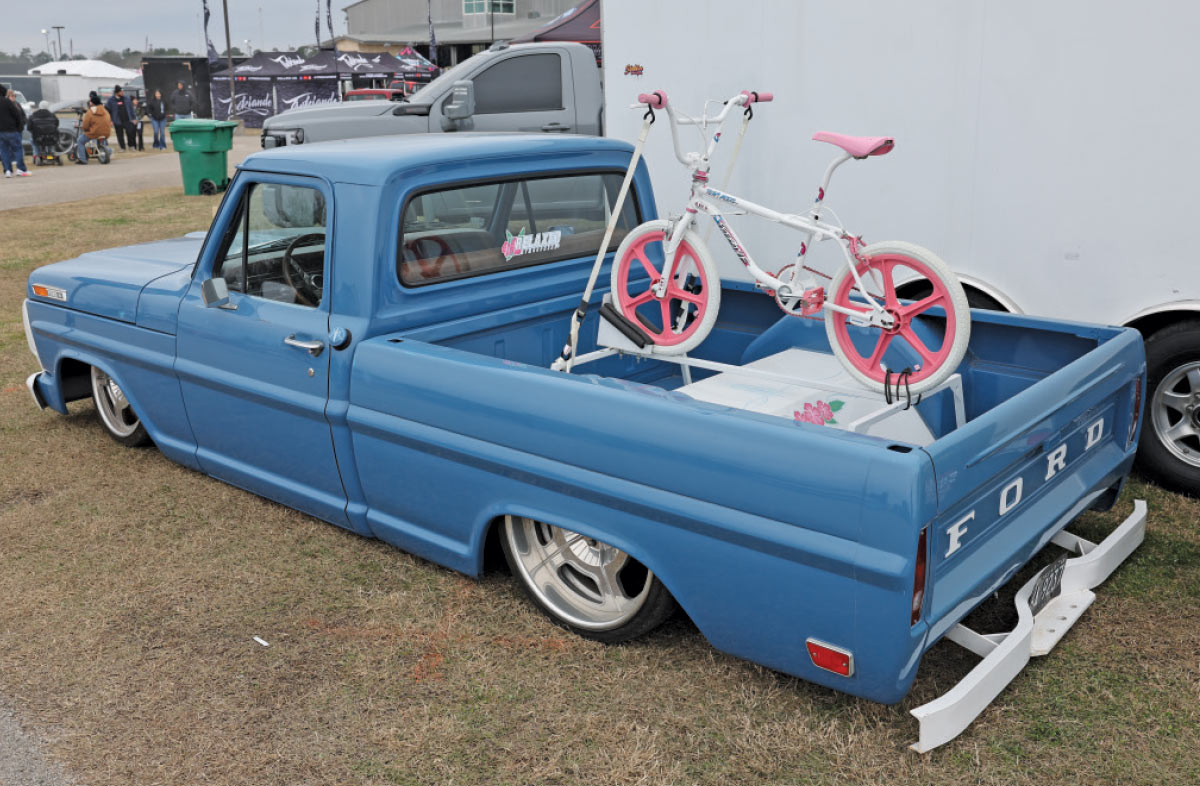 1970 Ford F100 in blue with billet wheels and a vintage BMX bike showcased in the bed