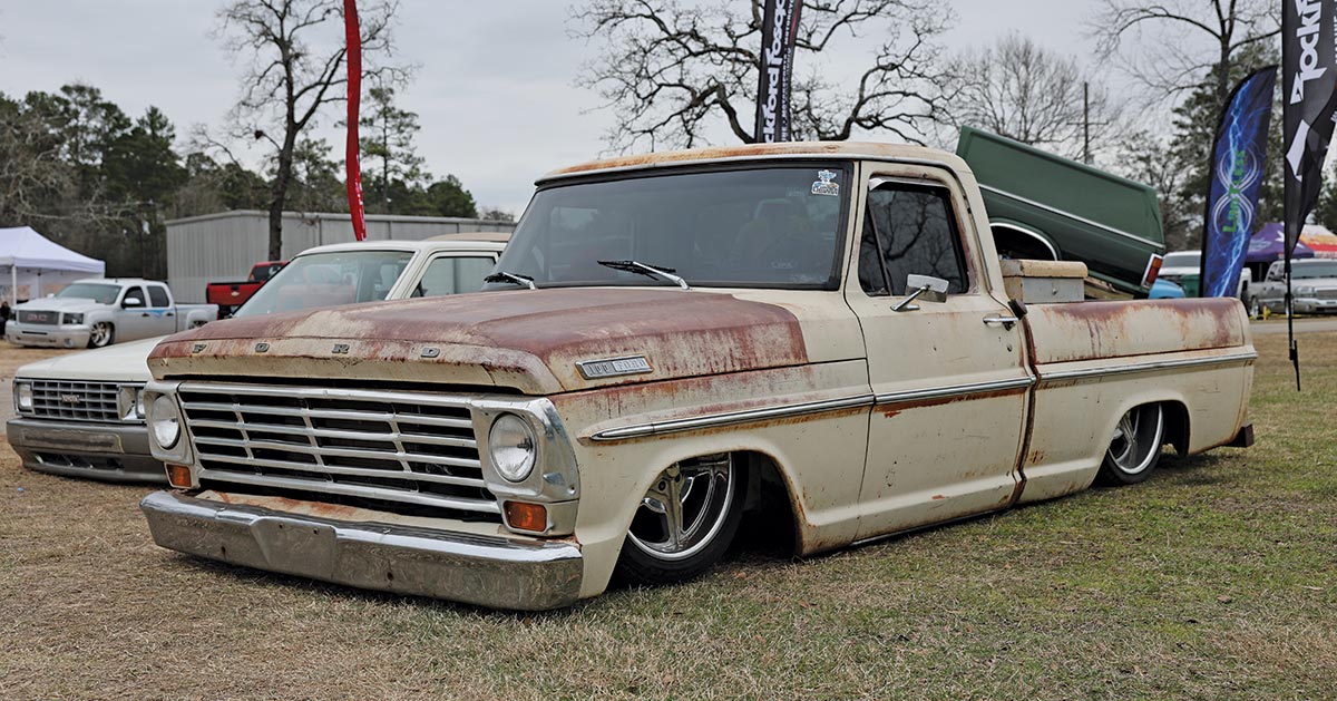 1969 Ford F-100 in patina cream and rust finish, laid out on deep-dish chrome wheels