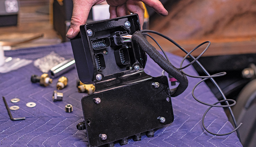 Electrical harness routed into the AccuAir ECU mounted to the VU4 manifold on padded workbench