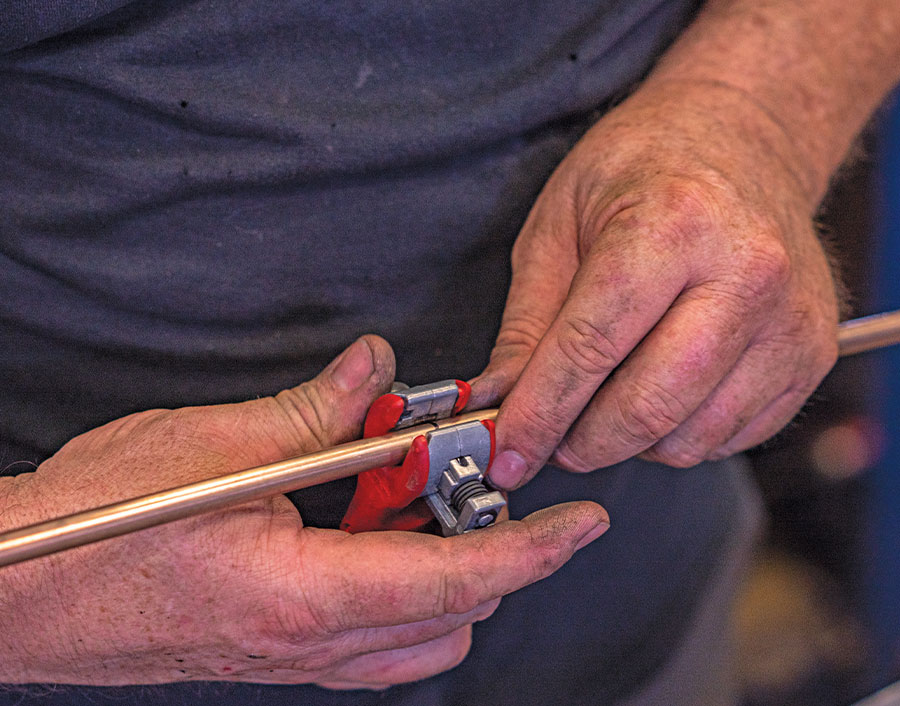 Cutting copper hard line with tubing cutter during custom air line fab for AccuAir setup