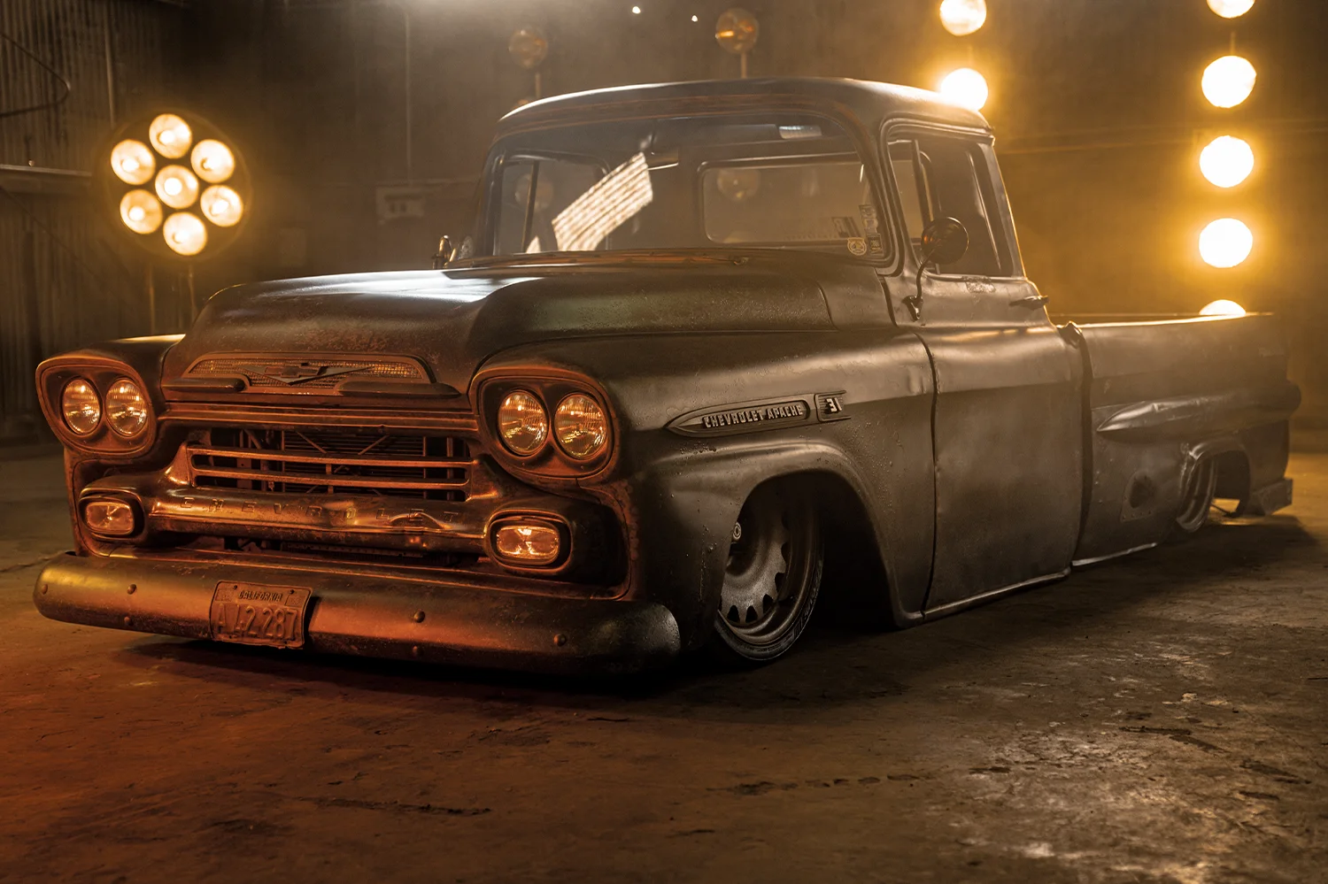 1959 Chevy Apache laid out on air suspension with moody lighting and patina finish