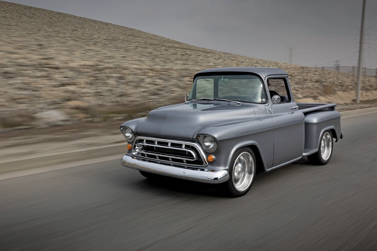 1957 Chevrolet Task Force pickup rolling shot with lowered stance and polished wheels