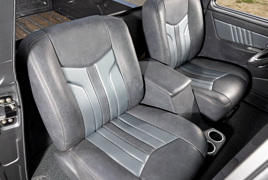 1957 Chevy truck interior with custom gray bucket seats and center console cupholders
