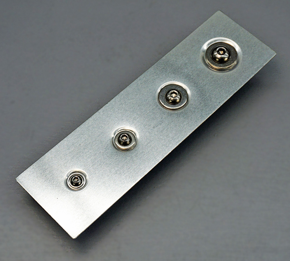 different types of precision-machined dimple dies laid out on a workbench