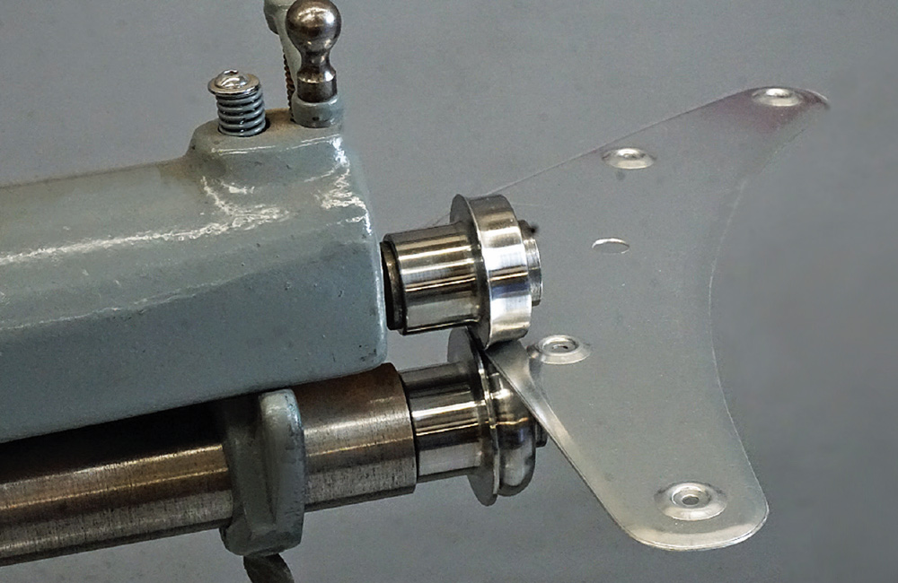 completed metal panel with dimpled holes being finished on a bead roller