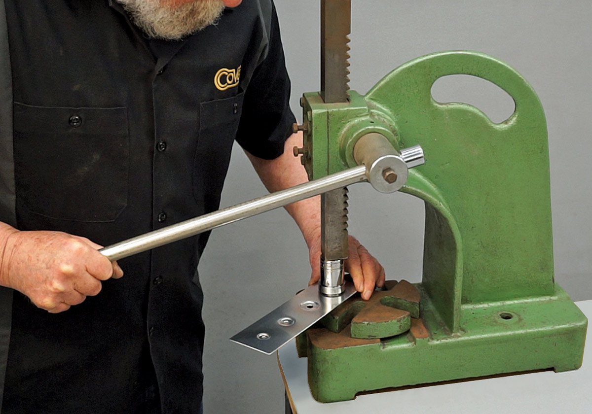 using a manual arbor press to create dimples in a sheet metal panel