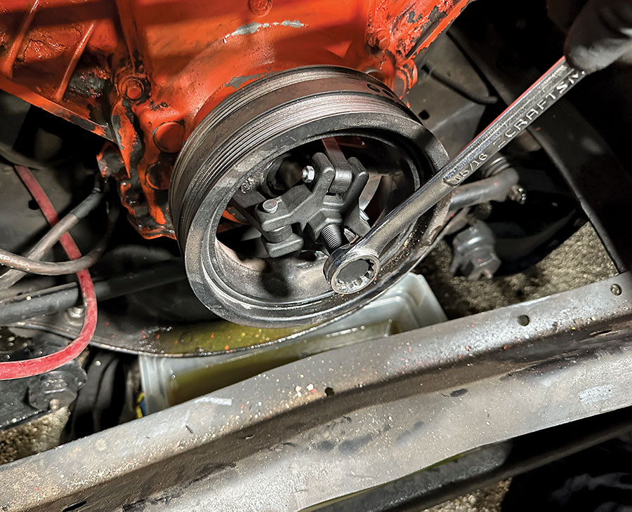 Harmonic balancer being pulled with a jaw puller during teardown