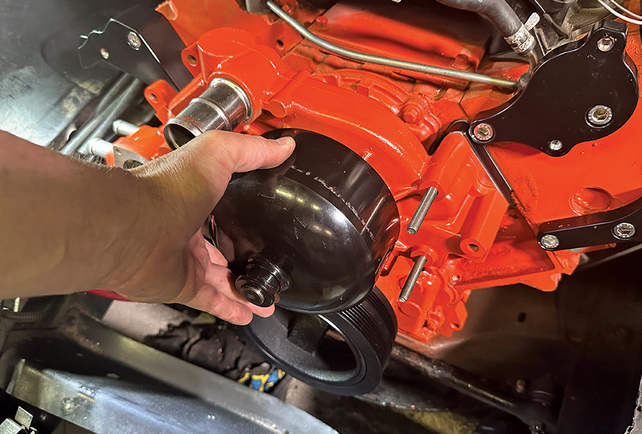 ACDelco water pump being test-fitted between billet brackets for final alignment