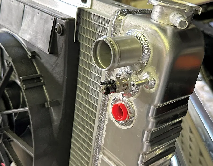 Close-up of radiator upper neck, fan sensor bung, and TIG-welded aluminum craftsmanship