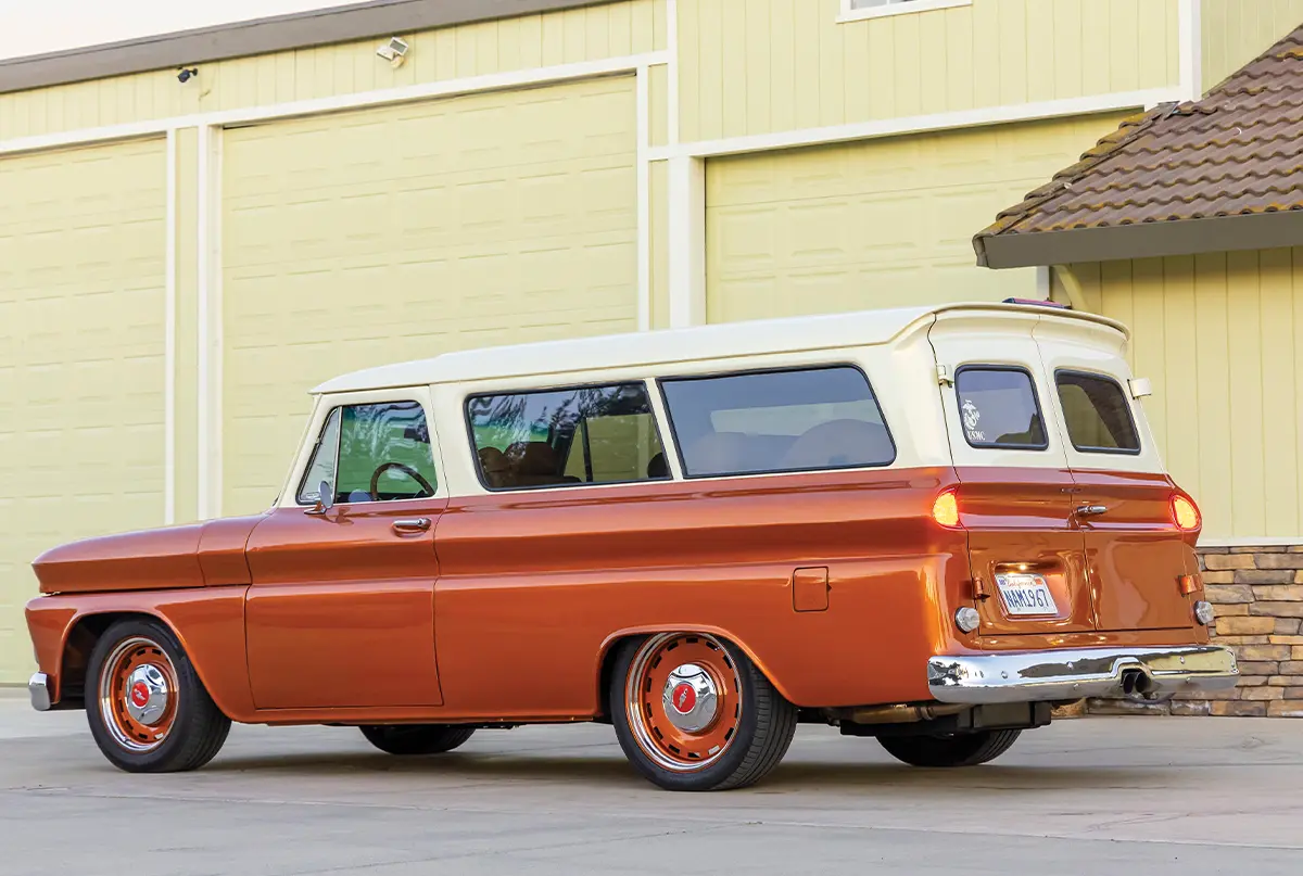 1966 Chevy Suburban shows dual barn doors and custom orange steel wheels with Chevy caps