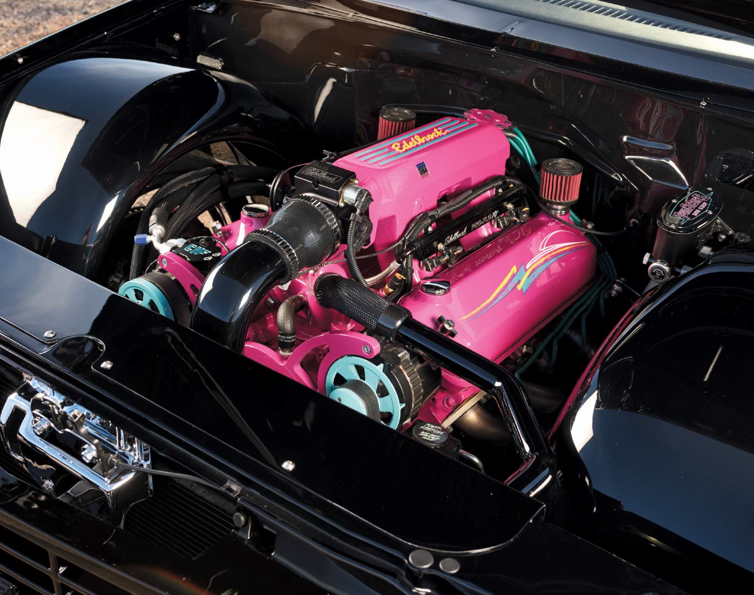 1993 Chevy OBS engine bay with hot pink Edelbrock valve covers, teal pulleys, and custom pinstriping