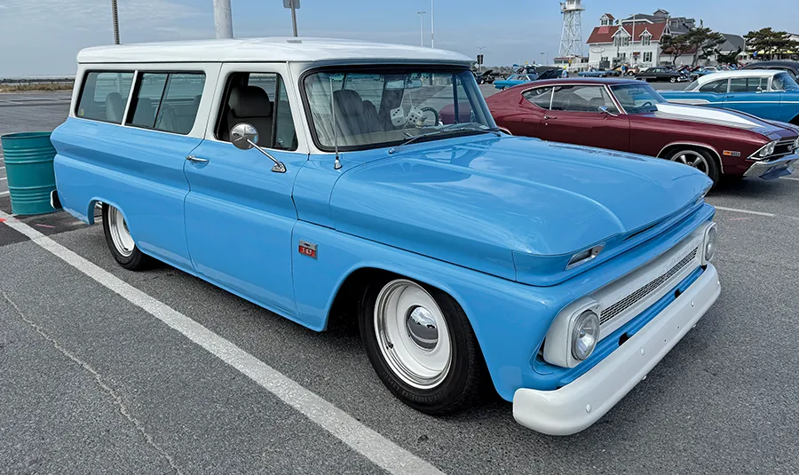 Classic truck restomod: a blue and white Chevrolet Suburban with a lowered suspension and clean styling, representing automotive restoration culture.