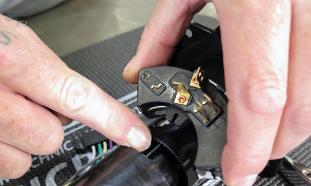 Installation of the neutral safety/backup light switch onto the steering column's shifter tube.