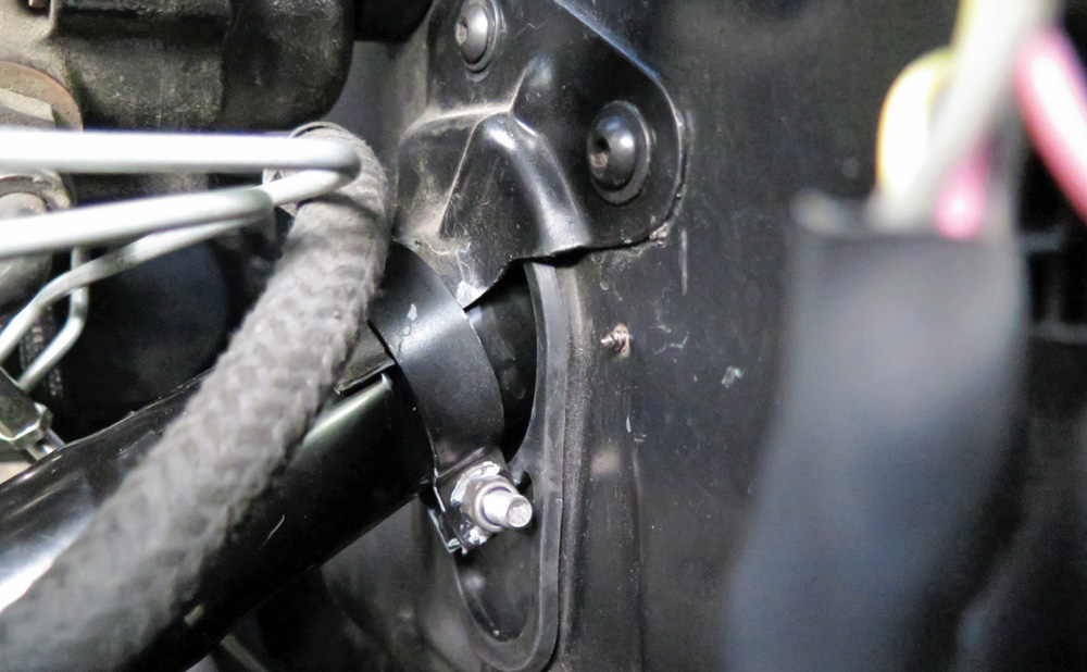 Securing the bottom of the steering column to the firewall with the original clamp and hardware.