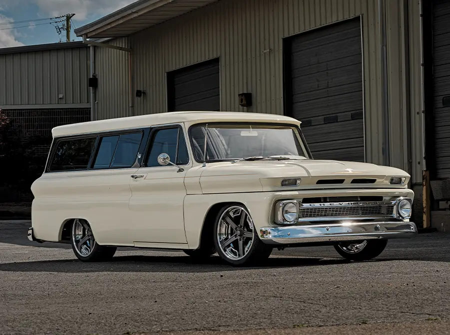 1966 Chevrolet Suburban three-quarter profile with custom wheels, lowered suspension, and clean body panels