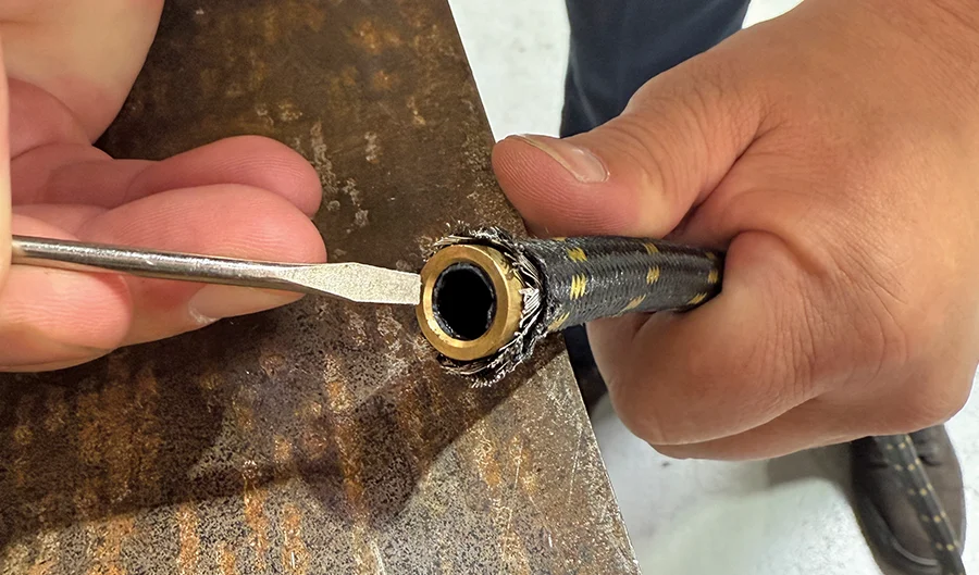 Spreading braided hose outer layer to verify alignment with brass insert