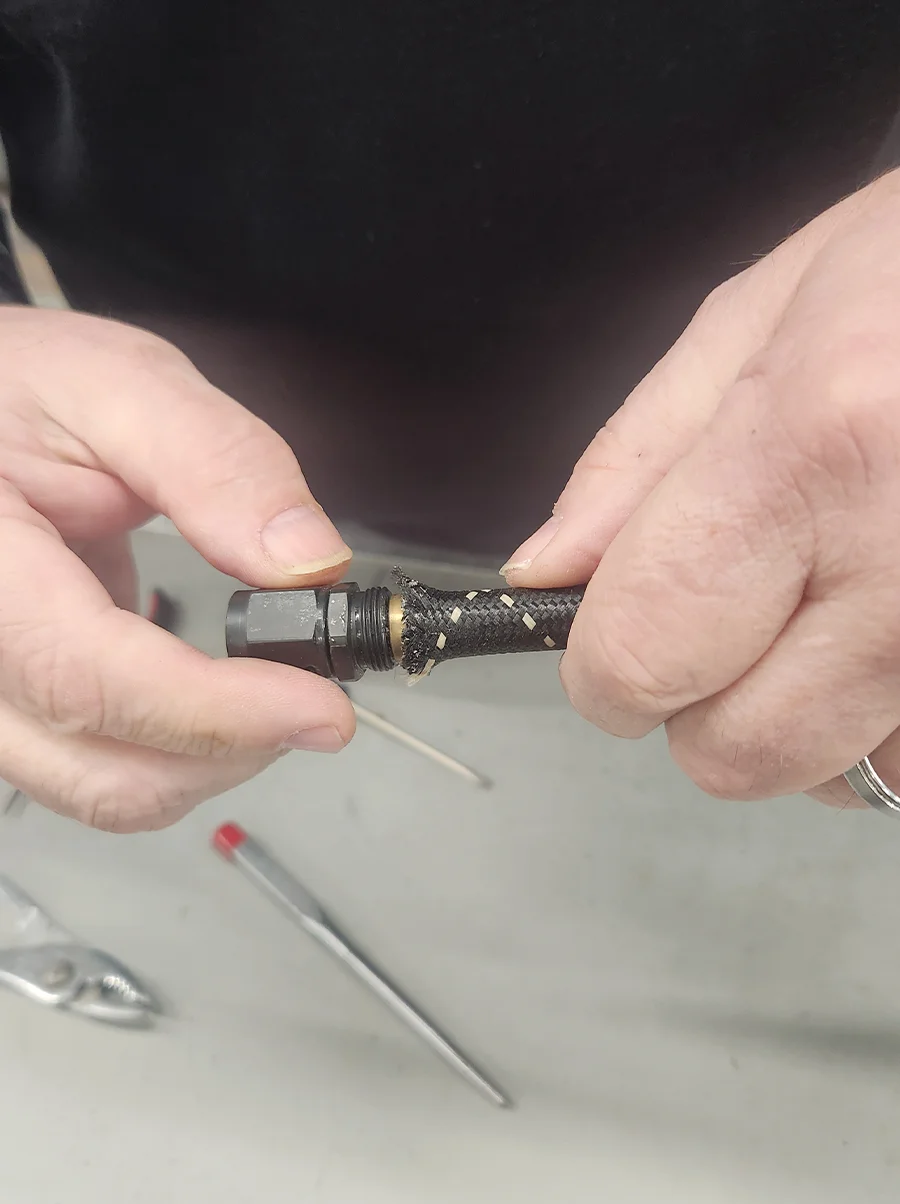 Threading AN hose collar onto brass insert with black fitting hand twist