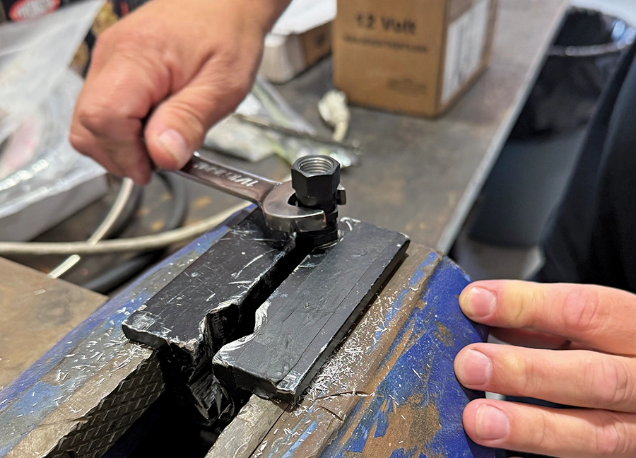 AN fitting final torque using vise jaws and wrench to complete assembly