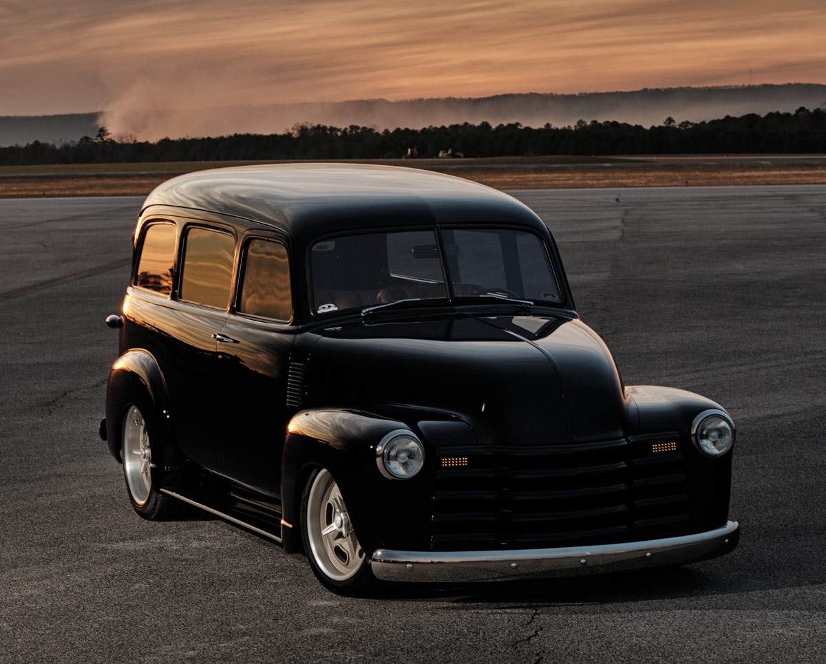 1952 Chevy Suburban, black, front three-quarter, runway sunset, reflections