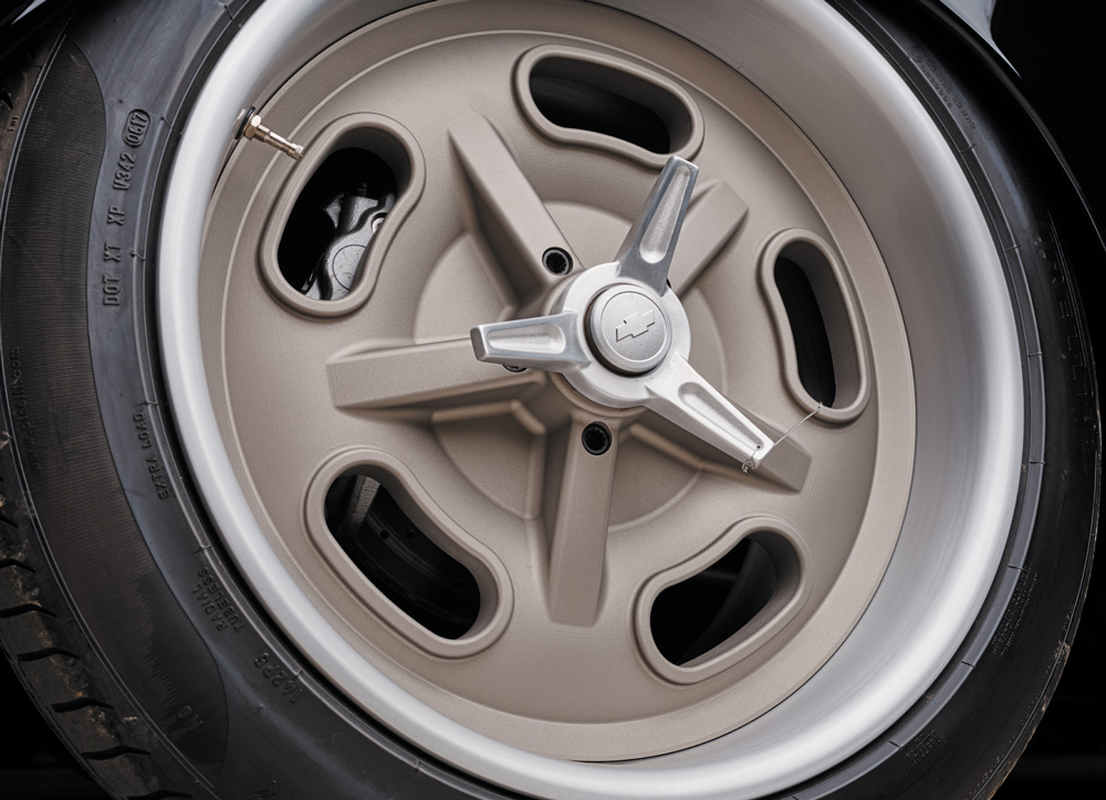 1952 Chevy Suburban wheel closeup, five-spoke alloy, center spinner, Chevy bowtie logo, tire sidewall text