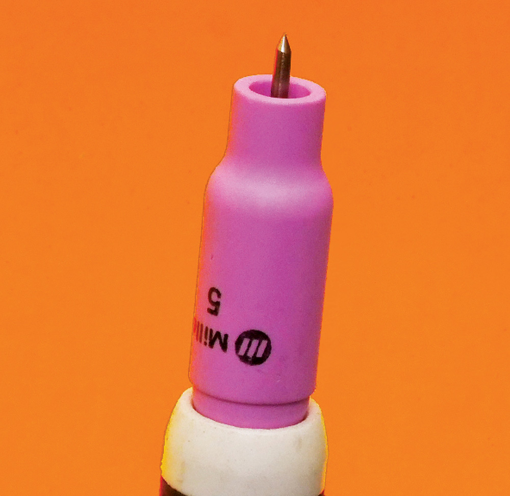 TIG torch with white ceramic cup, tungsten tip protruding, black handle partially visible, orange background