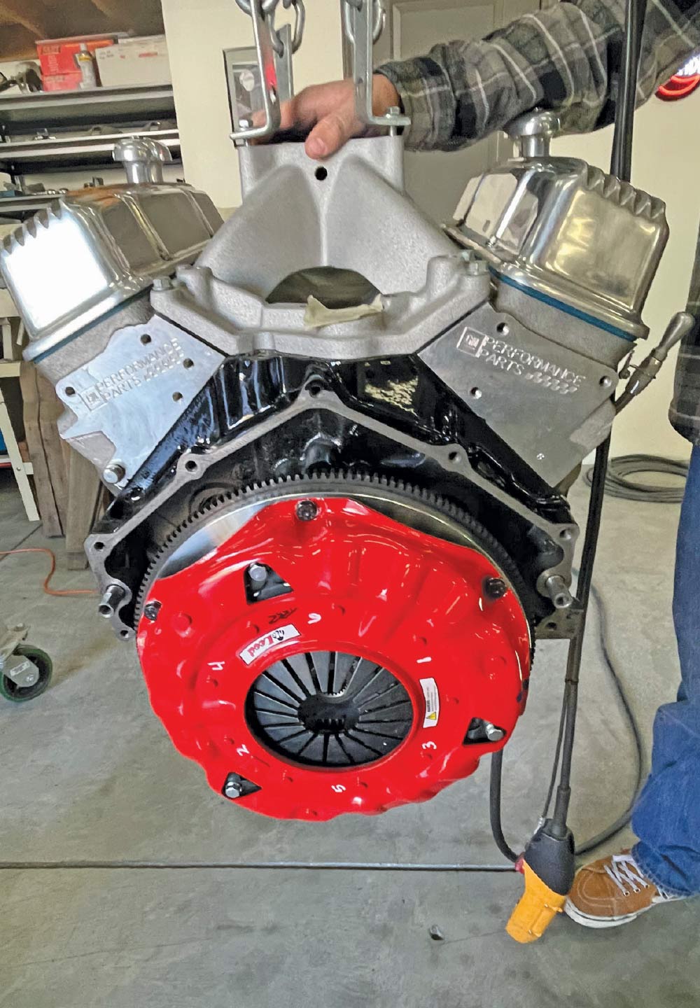 V8 engine with red clutch pressure plate assembly, flywheel installation, shop floor