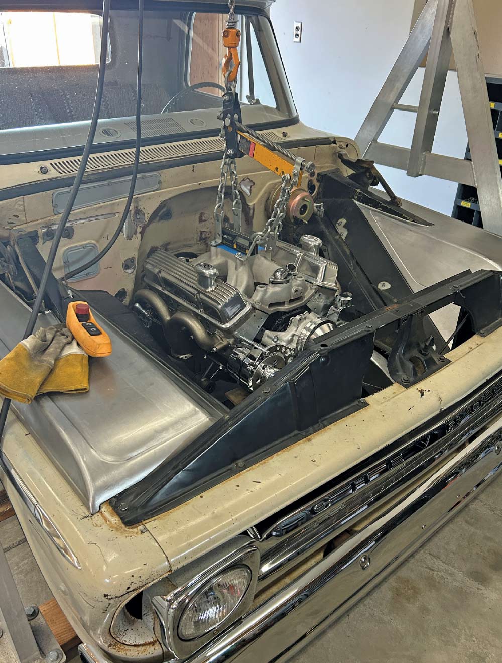V8 engine being installed in engine bay, custom metalwork, 1960s Chevrolet C10 truck