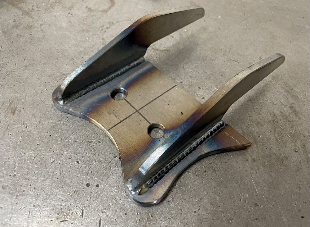 Welded steel transmission mount bracket, fresh fabrication, shop workbench, Chevy C10 parts