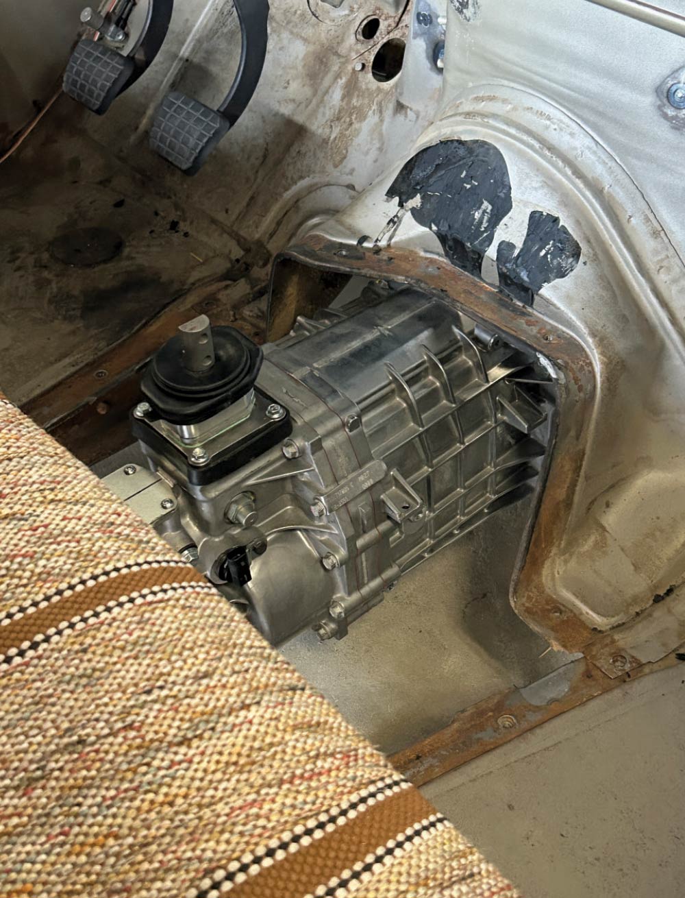 Interior Chevy C10, transmission tunnel with manual gearbox, exposed shifter, seat upholstery visible